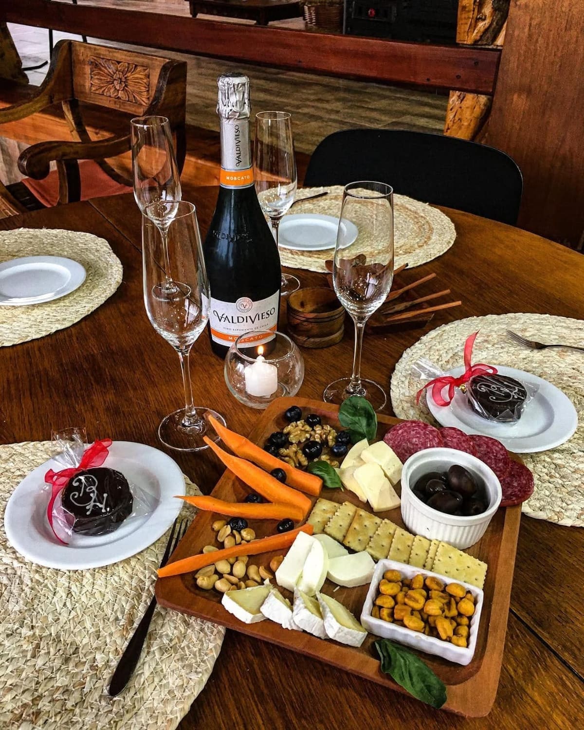 Mesa de bienvenida con vino espumante y tabla de quesos